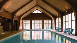 Ein Hallenbad mit Holzbalken und großen Fenstern.