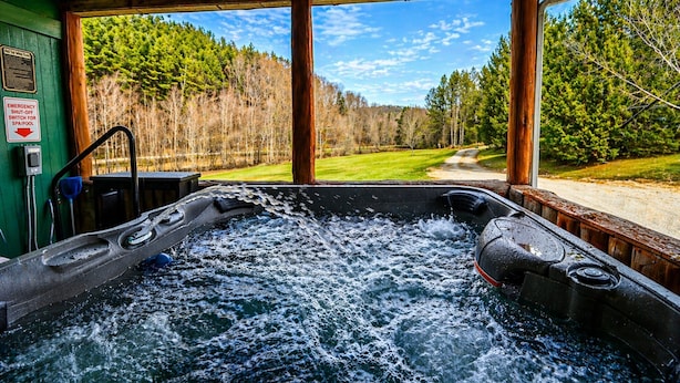 A hot tub with a view of a forest and a road. - Hot Tub Stream Stargazing Field Game Rm Telescope (Coudersport)
