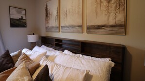 A hotel room with a bed, pillows, a lamp, and three framed paintings on the wall. - Hot Tub Stream Stargazing Field Game Rm Telescope (Coudersport)