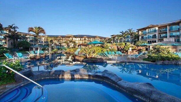 A resort pool area with multiple lounge chairs and a large pool. - Gorgeous 1BR/2BA - Great Views & Reviews (Kapaa)