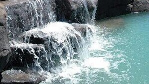 A hotel with a pool featuring a waterfall, palm trees, and a multi-story building with balconies. - Gorgeous 1BR/2BA - Great Views & Reviews (Kapaa)