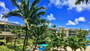 A resort with multiple buildings, palm trees, a swimming pool, and a beach area. - Gorgeous 1BR/2BA - Great Views & Reviews (Kapaa)