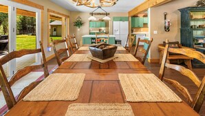 A dining room with a wooden table, chairs, and a central decorative bowl.