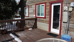 Une maison en bois avec une terrasse, une porte et une fenêtre.