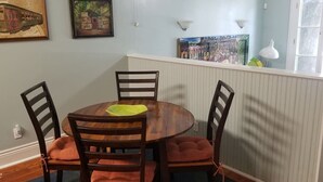 Ruokailutila, jossa on pyöreä pöytä, neljä tuolia ja ikkuna, josta on näkymä.