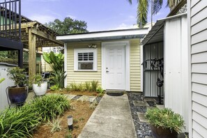 A residential property with a front door, a small porch, and a garden with various plants.