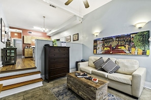 A living room with a sofa, a coffee table, a cabinet, and a painting on the wall.