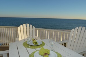 A table set for two with white chairs, overlooking a beach with the ocean in the background. - BOOK NOW! 4TH FLOOR-BEACH FRONT- TRADEWINDS (Orange Beach)
