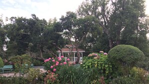 A gazebo surrounded by lush greenery and flowering plants. - Private Cottage, Amazing Gardens within a Gated Estate  - True European Charm! (Soquel)