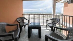 A balcony with a view of the beach, featuring two chairs and a small table. - AMAZING BEACH VIEWS! Next to Gulf State Park (Gulf Shores)