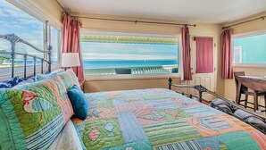 Ein Schlafzimmer mit einem großen Bett, Meerblick und einem Balkon.