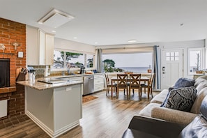 A modern kitchen with a central island, a dining area with a view, and a cozy seating area with a view. - Oceanfront Home with Spectacular Views on Monterey Bay.  (Pacific Grove)