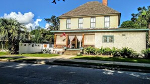 A two-story house with a porch, a chimney, and a small garden. - 2brCoastalColonialApt between Jekyll & St Simons Islands beaches& near Downtown! (Brunswick)