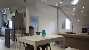 A modern kitchen with a dining area, a sofa, and a TV in a living room. - Fantastic - Cabo Girão view  (Câmara de Lobos)