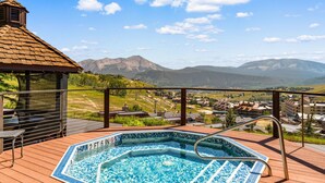 A hot tub on a wooden deck with a mountain view. - Columbine 2107 (Crested Butte)