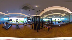 A gym with treadmills, elliptical machines, and weight equipment. - Hotel Blossoms (Tiruchirappalli)
