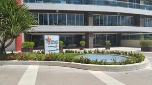 A modern building with a sign reading "Terraces do Atlântico" and a landscaped area with a circular water feature.