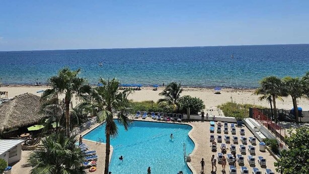 A pool area with a view of the beach and ocean. - Beachfront Studio  overlooking the Atlantic Ocean (Fort Lauderdale Beach)