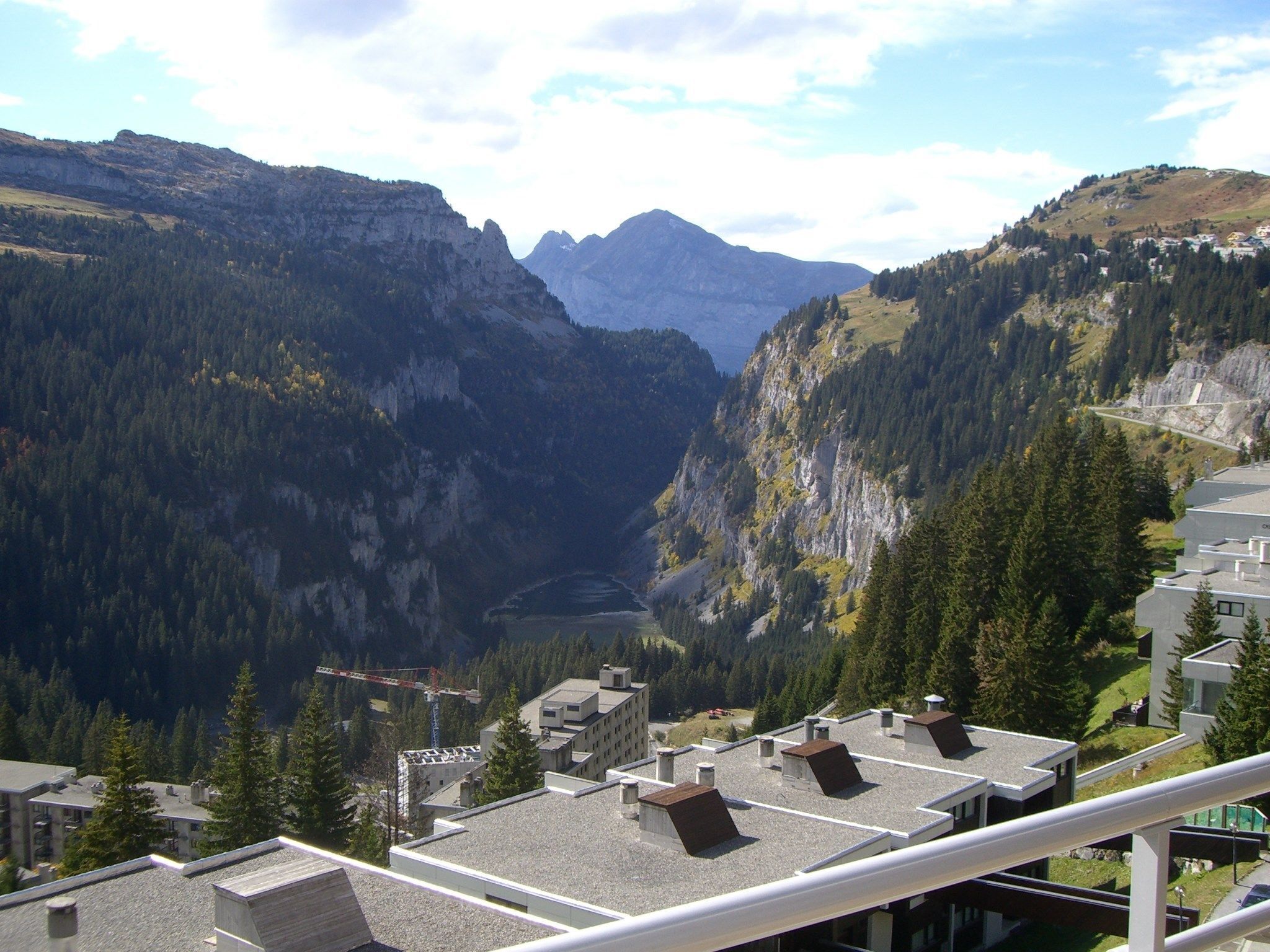 A mountain landscape with buildings featuring flat roofs and a valley.
