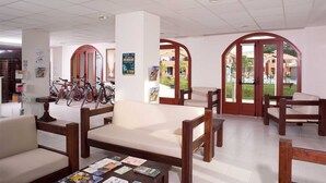 A spacious lobby with a coffee table, seating area, and bicycles.