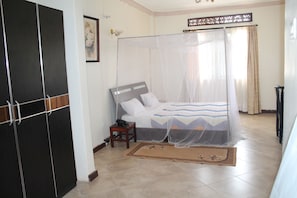 A bedroom with a bed, bedside table, and a wardrobe.