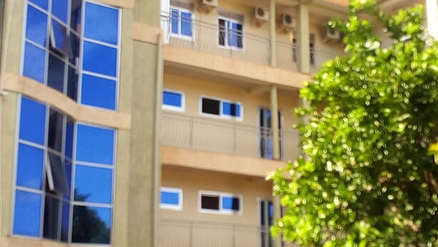 A multi-story building with large windows and balconies. - Golden Peace Hotel (Gulu)