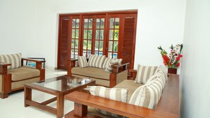 A living room with a sofa set, a coffee table, and a wooden door with glass panels.