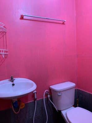 A bathroom with a white sink, toilet, and a towel rack on the wall. - At Trin Khao Kho (Khao Kho)