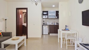 A compact living space with a kitchenette, a dining area, and a seating area. - NHE Rothschild Allenby Apartments (Tel Aviv)
