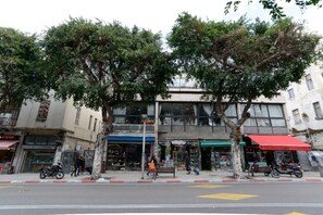 A street view with a cafe, a bookstore, and a building with a balcony.