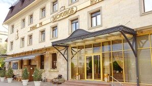 A hotel with a classic facade, large windows, and a covered entrance area. - Sacvoyage Hotel (Almaty)