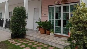 A multi-story building with a white facade, balconies, and a front entrance with glass doors. - Patchy&PPraw Family (Ubon Ratchathani)
