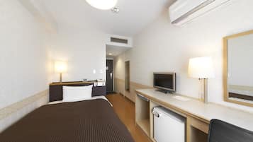 A hotel room with a bed, desk, television, and a mirror.