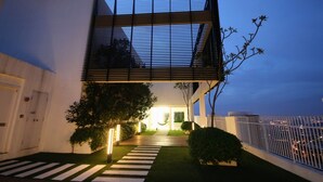 Un edificio moderno de dos plantas con techo plano, ventanas amplias y una entrada bien iluminada.