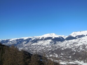 Eine Berglandschaft mit schneebedeckten Gipfeln und blauem Himmel.