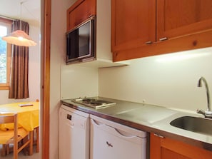 A compact kitchen with a built-in microwave, a dishwasher, and a sink.
