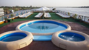 A pool area with three circular pools and lounge chairs facing the water. - Nile Carnival Cruise (Luxor)