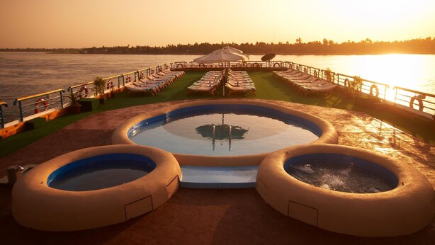 A pool area with multiple water features and lounge chairs. - Nile Carnival Cruise (Luxor)