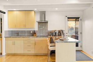 A modern kitchen with wooden cabinets, a stainless steel range hood, and a tiled backsplash. - Eagle Dancer Upper Casita | Majestic Desert Views (Sedona)