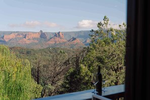 Une vue sur un paysage montagneux, avec des arbres et un ciel dégagé.