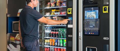 A vending machine with a variety of snacks and drinks, including chips, soda, and bottled water.