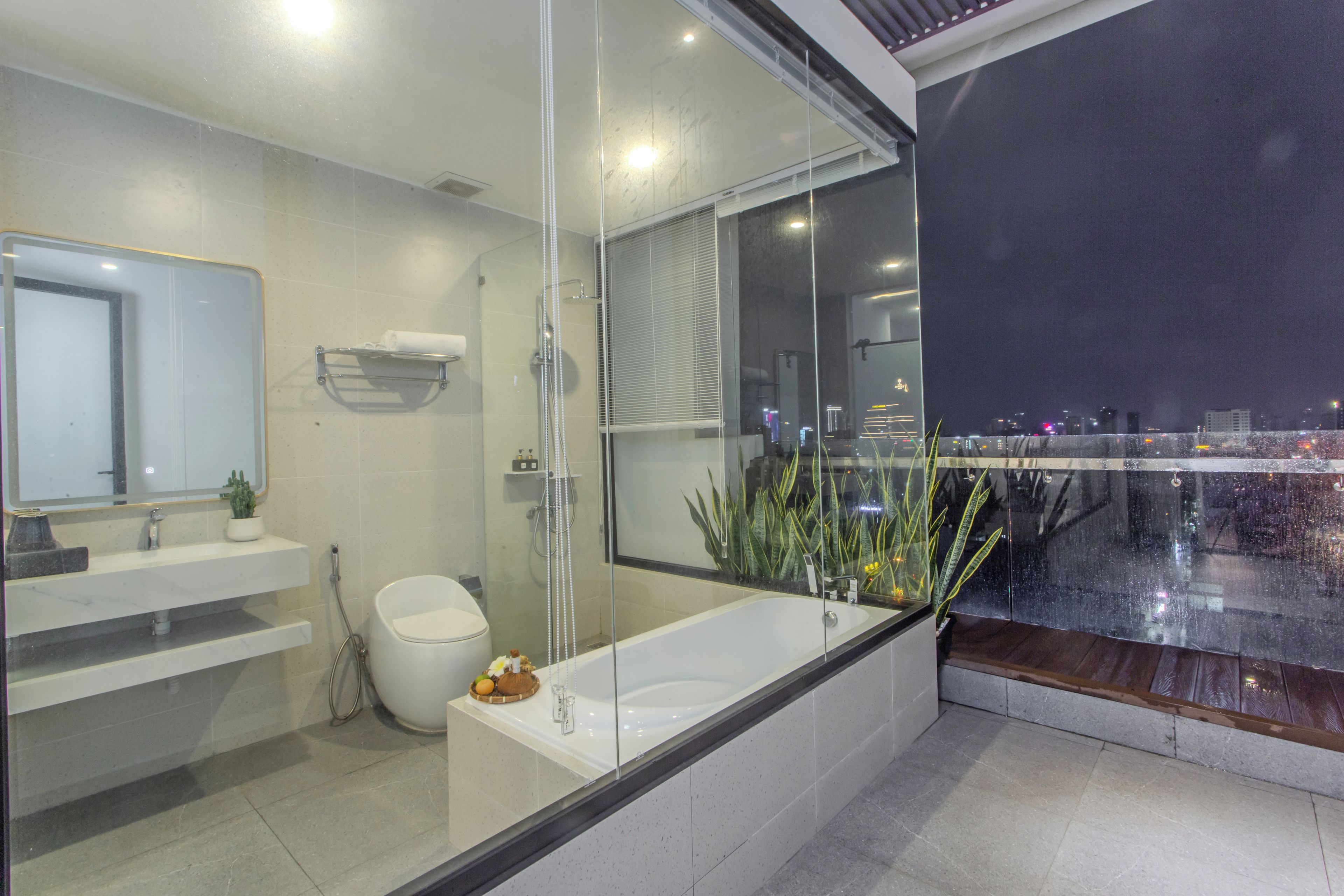 A modern bathroom with a glass-enclosed shower, a bathtub, and a toilet.