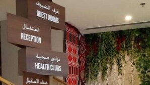A hotel interior with a signpost indicating guest rooms, reception, health clubs, concierge, and a coffee shop. - Jacob's Garden Hotel (Dubai)
