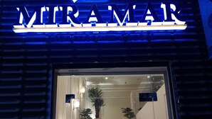 Entrada de hotel con un cartel que dice "VITRAMAR" y una escalera que conduce al interior.