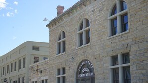A historic stone building with a sign reading "Idaho State Penitentiary." - Cottage by the Historic Depot (Boise)