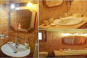 Un bany amb un lavabo gran, un mirall i un vàter.