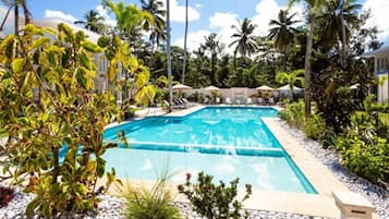 Una piscina al aire libre, sillones reclinables de piscina