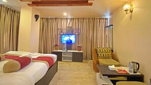 A hotel room with a bed, a sofa, a TV, and a desk. - Hotel Readers Inn Pvt.Ltd (Kathmandu)