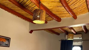 A room with two beds, a wooden ceiling, a window with curtains, and a painting on the wall. - Dar Boumida (Lalla Takarkoust)