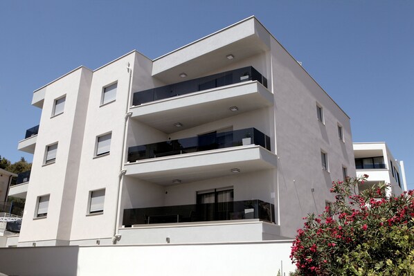 A multi-story building with balconies, a flat roof, and a clear sky. - Villa Aquamarie (Trogir)